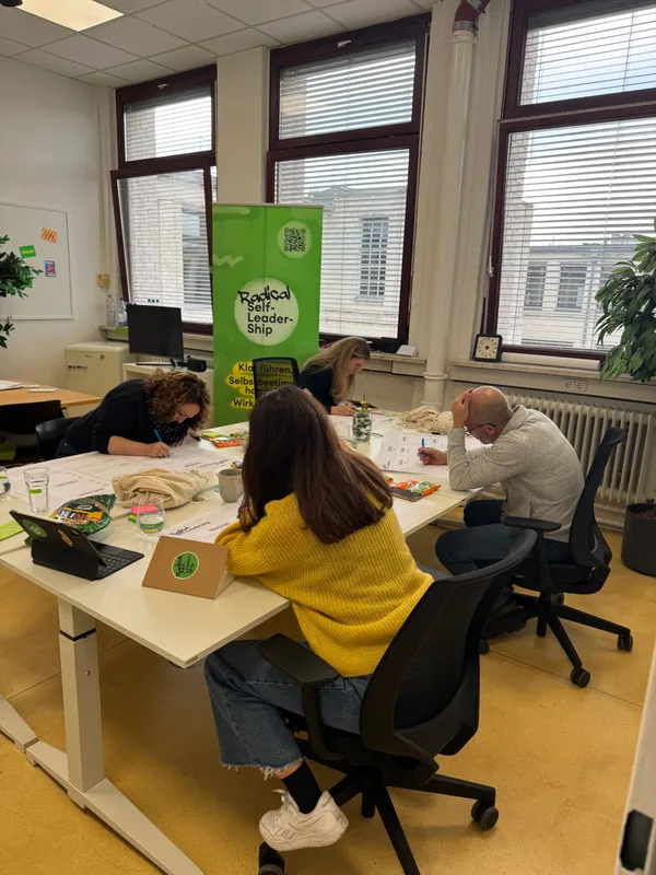 Vier Teilnehmende arbeiten konzentriert an ihren Canvas-Bögen