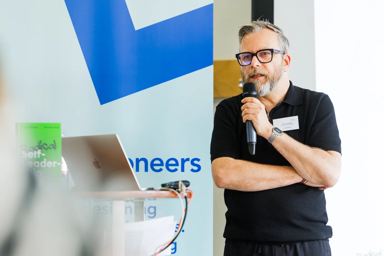 Thorsten Reitz mit verschränkten Armen vor dem Pioneers-Banner.